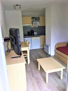 uma pequena sala de estar com televisão e cozinha em Skis aux pieds station 1600 Sun Vallée em Puy-Saint-Vincent