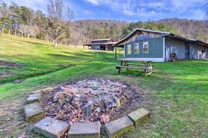 a fire in a yard next to a house at Cherokee Natl Forest Retreat Renovated Cabin! in Greeneville