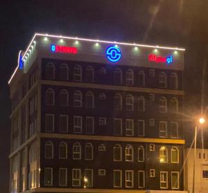 a building with a sign on top of it at night at Ostrava Suites in Abha