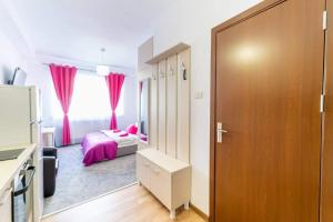 um quarto com uma cama e uma janela com cortinas cor-de-rosa em Apartament Cristian em Arad