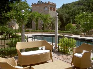 a patio with chairs and a pool and a building at Castello Delle Serre in Rapolano Terme