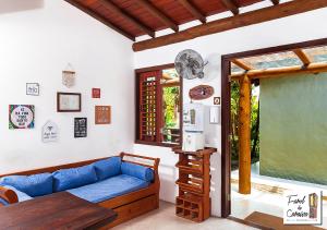 a living room with a blue couch and a table at Pousada Farol de Caraíva in Caraíva