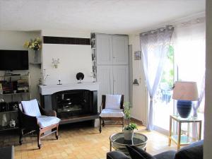 uma sala de estar com lareira e 2 cadeiras em LOUCABANON VAR em Draguignan