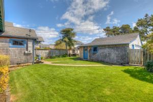 a yard with a house and a fence at Byers Boathouse on the Prom - Meredith Lodging in Seaside