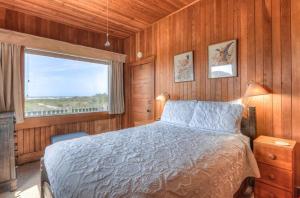 a bedroom with a large bed and a window at Byers Boathouse on the Prom - Meredith Lodging in Seaside