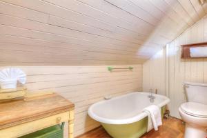 a bathroom with a white tub and a toilet at Byers Boathouse on the Prom - Meredith Lodging in Seaside +49 photos