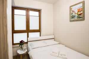 una camera bianca con un letto e una finestra di Dream&Travel Apartments a Cracovia