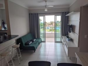 un soggiorno con divano verde e balcone di Apartamento VIP com Vista para o Mar a Ubatuba