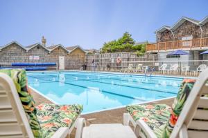 a swimming pool with chaise lounge chairs in a hotel at Crow's Coastal Cottage in Waldport