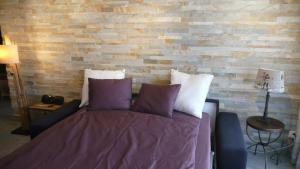 Ce lit se trouve dans une chambre dotée d'un mur en briques. dans l'établissement Hausroc-Zermatt, à Zermatt