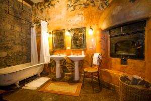a bathroom with two sinks and a bath tub at Hacienda San Agustin de Callo in Lasso