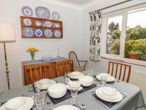 a dining room with a table with plates on it at Ty Caeredin in Llandudno