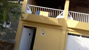 a building with a white door and a balcony at Santa Helena Pousada in Cachoeira Paulista