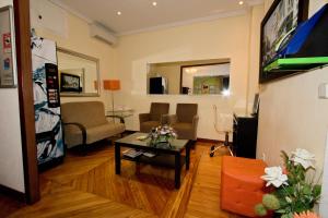 un soggiorno con un divano e un tavolo di Hostal Los Alpes a Madrid