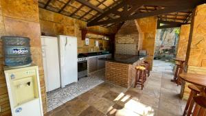 a kitchen with a white refrigerator and a table at Castelo das Dunas Camping e MotorHome in Paracuru