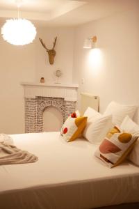 a bedroom with a white bed with a fireplace at Oboho - Le gîte bohème (Pieds dans l’eau - Lit King Size - Jardin) in Esneux