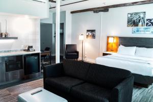 um quarto de hotel com uma cama e um sofá em Hotel Millwright em Amana