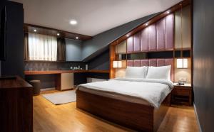 sypialnia z dużym łóżkiem z drewnianym zagłówkiem w obiekcie Vitabella Suites w Stambule