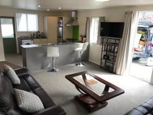 - un salon avec un canapé et une table dans l'établissement Westland Apartment, à Dunedin