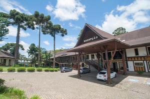 um hotel com carros estacionados num parque de estacionamento em La Dolce Vita Park Hotel - Próximo a Curitiba em São José dos Pinhais