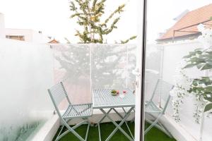 Dos sillas y una mesa en un balcón. en Casa 53, en Aveiro