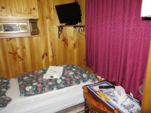 a small room with a bed and a television at Karelia Alpine Lodge in Falls Creek