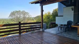 una terrazza in legno con tavolo e sedie su una casa di Casa en las Sierras de Córdoba a Unquillo