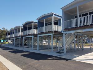 a row of houses with balconies on a street at Pelican Caravan Park in Nambucca Heads