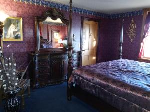 ein Schlafzimmer mit einem Bett und einem großen Spiegel in der Unterkunft The Thayer in Annandale