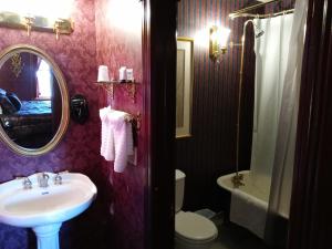 a bathroom with a sink and a toilet and a mirror at The Thayer in Annandale