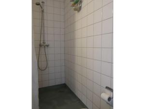 y baño con ducha y azulejos blancos. en ApartmentInCopenhagen Apartment 743, en Copenhague