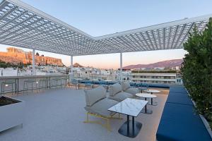 a patio with couches and tables on a building at Acro Urban Suites in Athens