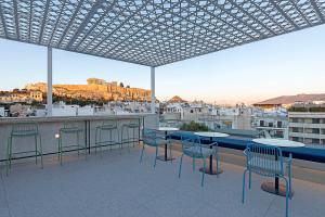a patio with tables and chairs and a view of a city at Acro Urban Suites in Athens