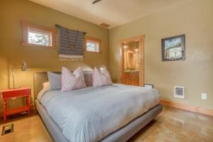 a bedroom with a large bed with pink pillows at The Davenport - Meredith Lodging in Bend