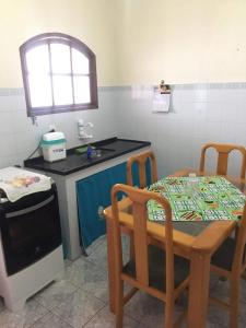 een keuken met een tafel en stoelen en een wastafel bij Flavia Aluguel Temporada in Cabo Frio