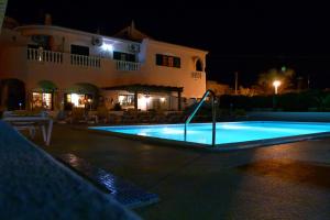 a swimming pool in front of a house at night at Solar de Mos in Lagos
