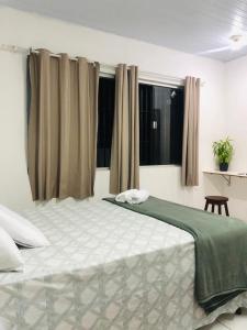 A bed or beds in a room at Pousada Center