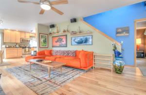 sala de estar con sofá naranja y mesa en The Undertow, en Pacific City