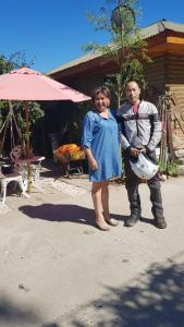 un hombre y una mujer parados frente a una casa en Cabañas Rukas Licantén, en Licantén