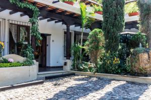 a house with a courtyard with trees and plants at Villa 14 Santa Ines Antigua Guatemala in Antigua Guatemala