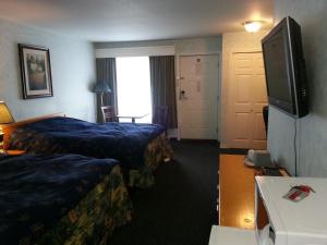 a hotel room with two beds and a flat screen tv at Heritage Inn in Hope