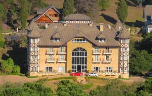 a large house with a red car parked in front of it at Carballo Hotel & Spa in Campos do Jordão