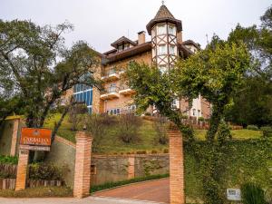 a building with a clock tower on top of a hill at Carballo Hotel & Spa in Campos do Jordão