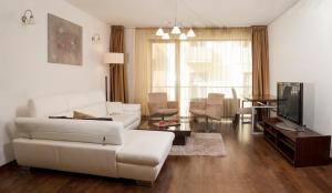 ein Wohnzimmer mit einem weißen Sofa und einem Tisch in der Unterkunft Luxury Downtown Apartments in Budapest