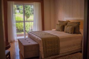 a bedroom with a large bed and a window at Carballo Hotel & Spa in Campos do Jordão