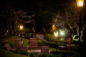 a group of lawn chairs and lights at night at Carballo Hotel & Spa in Campos do Jordão