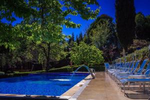 a row of chairs sitting next to a swimming pool at Carballo Hotel & Spa in Campos do Jordão