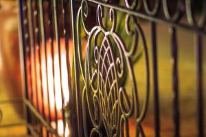 a iron fence with a fire in the background at Carballo Hotel & Spa in Campos do Jordão