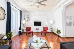 a living room with red chairs and a tv at vip LETRAS, by MONARO in Madrid