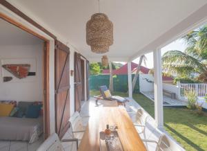 a living room with a wooden table and chairs at ROCHES PERCEES *** in Terre-de-Haut